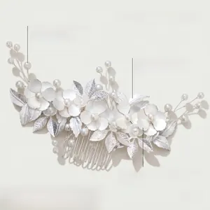 Detail of handmade silver floral hair comb with pearls and matte leaf texture on white background