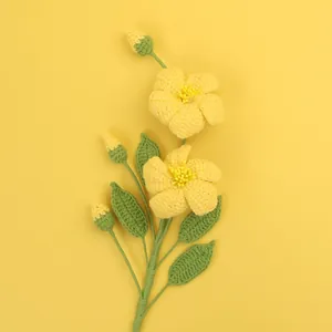 Bouquet de fleurs au crochet fait main avec fleurs jaunes et feuilles vertes sur fond uni