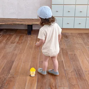 Infant summer short sleeve bodysuit set with sun hat and sandals on wooden floor