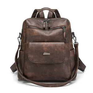 Detailed view of a dark brown vintage faux leather backpack with metallic zippers