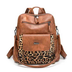 Close-up of leopard print stitching and smooth brown PU leather on women's backpack