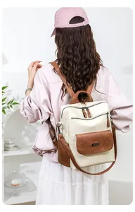 Modern women's backpack in beige and brown PU leather worn by a model in a cozy room