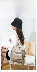 Detail view of large capacity beige PU leather backpack with multiple zip compartments