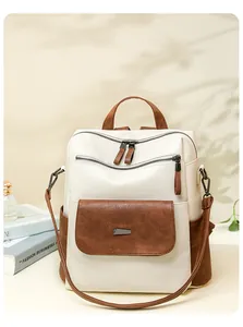 Close-up of color-block backpack showing lychee texture leather and metal hardware detail