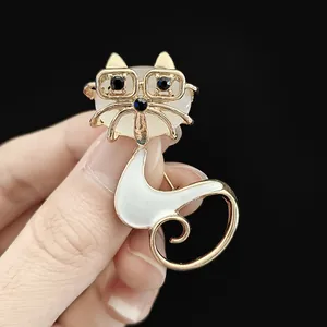 Detailed macro shot of a gold cat brooch with glasses and opal stone inlay