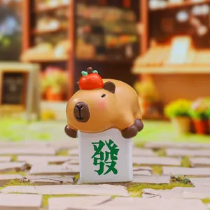 Close-up of cute capybara figurine with a red persimmon on top and a lucky base