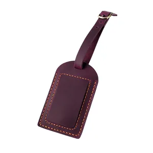 Detail of purple crazy horse leather luggage tag with orange contrast stitching and buckle
