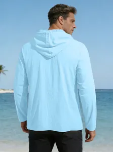 Rear view of light blue linen hooded shirt on a beach with sea and sky background