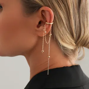 Close-up of golden tassel ear cuff featuring dangling chains with small metal beads