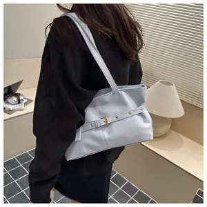 Détail du sac cabas en cuir ciré bleu clair avec sangle décorative et boucle dorée