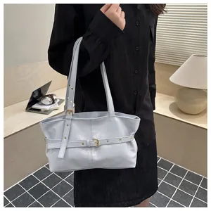 Détail du sac cabas en cuir ciré bleu clair avec texture fine et bandoulières chic