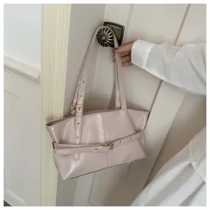 Détail du sac cabas en cuir ciré rose pâle avec œillets métalliques sur poignée vintage