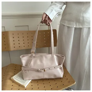 Détail de la texture en cuir ciré raffiné et de la boucle sur ce sac à bandoulière chic