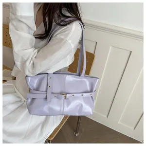 Détail du sac en cuir ciré lavande avec texture brillante et boucles dorées