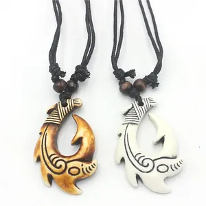 Detail view of Hei Matau fish hook pendants with traditional tribal wave patterns