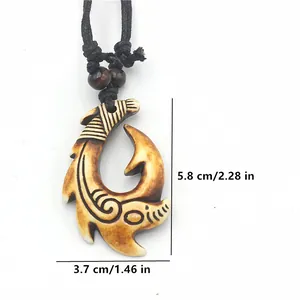 Detail view of Maori style fish hook pendant with engraved patterns and dimensions