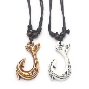 Detailed close-up of Māori fish hook pendants with tribal engravings and woven ropes
