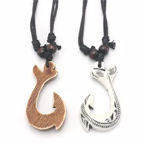 Detail of Maori style resin fish hook pendants with ethnic wood grain and tribal patterns