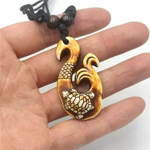 Macro detail of Maori fish hook pendant with carved turtle texture and brown finish