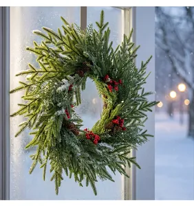 Detailansicht eines künstlichen Weihnachts-Kiefernkranzes mit roten Beeren und Schnee