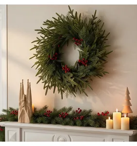 Weihnachtskranz aus Tannennadeln mit roten Beeren über einem dekorierten Kamin