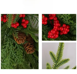 Makro-Detailansicht der künstlichen Weihnachtsgirlande mit roten Beeren und Naturzapfen.