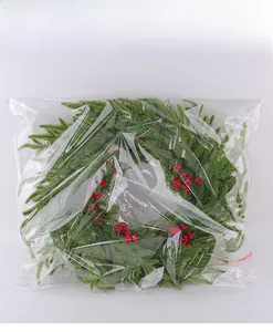 Künstlicher Weihnachtskranz mit Beeren und Zapfen in transparenter Verpackung