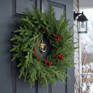 Üppiger künstlicher Weihnachtskranz mit roten Beeren und Tannenzapfen an dunkler Tür