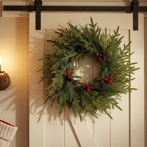 Künstlicher Weihnachts-Kranz mit Kiefernnadeln, roten Beeren und Zapfen an Scheunentor.