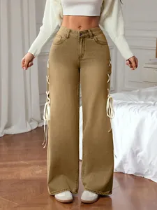 Detail of high waisted wide leg trousers featuring side white ribbon lace-up design