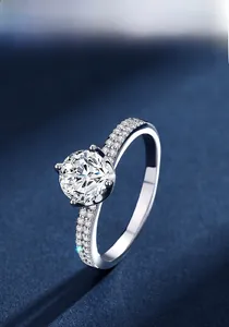 Close-up of a sparkling 1-carat Moissanite ring in 925 silver on blue background