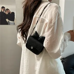 Sweet girl's black quilted crossbody bag with oversized bow and camellia clasp detail