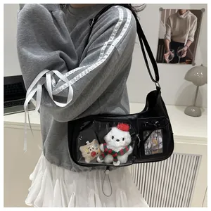 Detail of black ita bag with transparent window, plush dog charm and silk bow accent