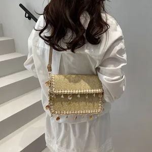 Borsa in paglia con perle e conchiglie e tracolla regolabile in pelle per l'estate 2025