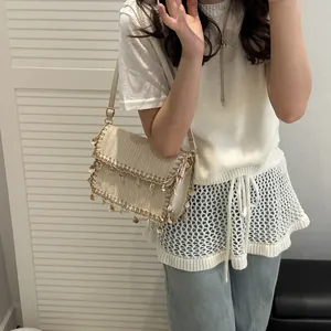 Borsa a tracolla intrecciata beige con ciondoli a conchiglia e perle per l'estate