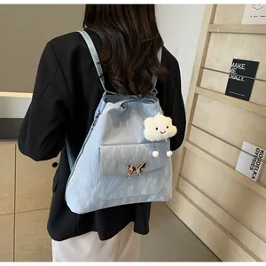 Detail of light blue wrinkled fabric backpack with butterfly buckle and cloud charm