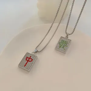 Detailed close-up of Mahjong pendants with iced-out crystals and Chinese characters