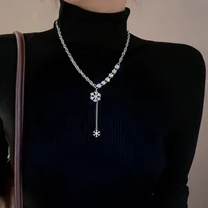 Elegant silver snowflake fringe Y-necklace with blue zircon on black sweater