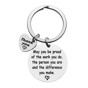 Close-up of engraved stainless steel heart and circle pendants on a metal keychain