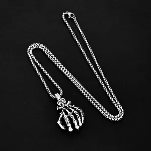 Collier punk gothique avec pendentif main de squelette sur fond noir élégant