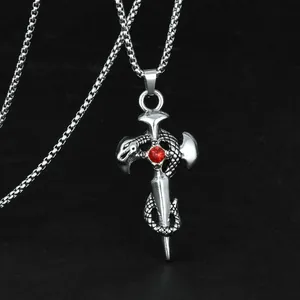 Close-up of gothic sword cross pendant with silver snake and red crystal gem detail