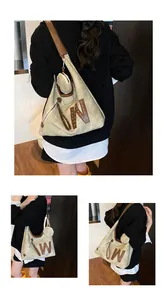 Close-up of khaki canvas hobo bag with leather W patch, metal rivets and a round coin purse