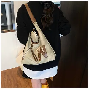 Detail of khaki canvas tote with brown leather straps and mini round coin pouch attachment