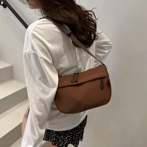 Brown waterproof nylon crossbody bag with adjustable wide strap for casual commuting