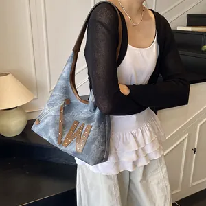 Vintage denim and leather shoulder bag with large W letter patch and rivet details