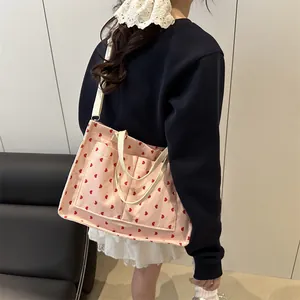 Pink corduroy tote bag with red heart pattern and dual pockets for daily commute