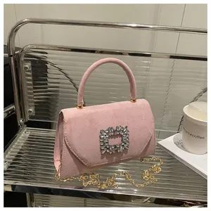Dettaglio borsa scamosciata rosa con fibbia in cristallo lucido e catena dorata