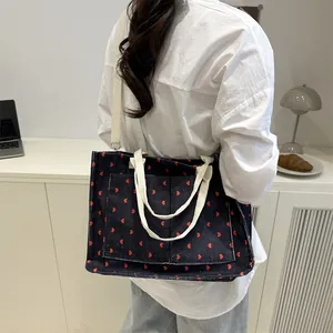 Blue corduroy tote bag with red hearts featuring front pocket and canvas straps
