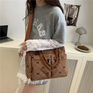 Brown corduroy tote bag with diamond bow pattern shown in a daily commute setting