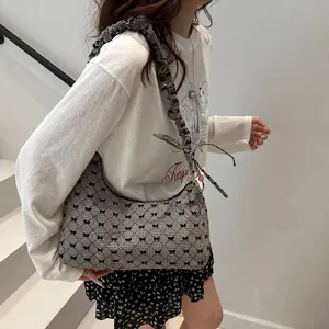 Plaid hobo shoulder bag with bow prints and ruffled strap shown in a lifestyle setting